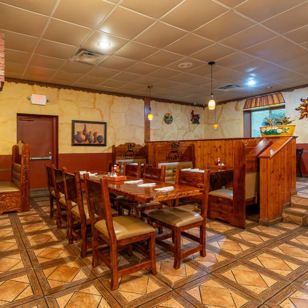 Mis Arcos Mexican Restaurant dining room with wooden tables, chairs, booths, and decorative wall art.