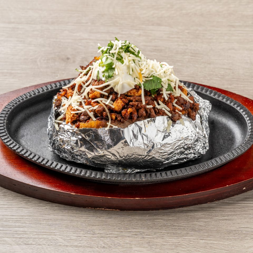 Mis Arcos Mexican Restaurant's baked potato, loaded with meat, cheese, sour cream, and cilantro.